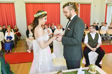 Der Bräutigam steckt der Braut den Ehering an.