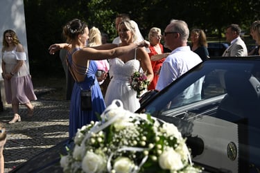 Braut wird nach der Trauung von Gästen im Freien beglückwünscht