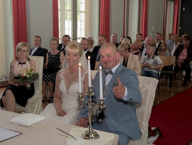 Brautpaar während der standesamtlichen Trauung in Hennigsdorf, umgeben von Familie und Freunden.