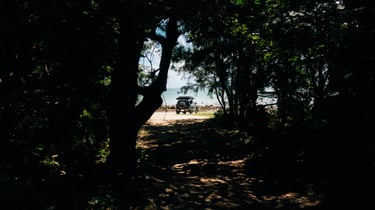 Toyota FJ Cruiser viewed through a forest path, parked near the beach in Okinawa. | Evertrail Okinawa