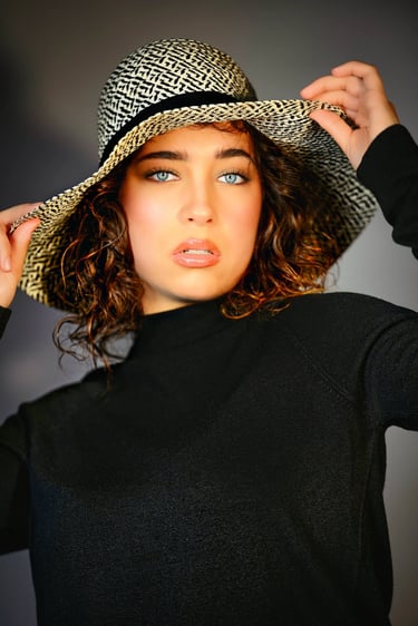 Cinematisches Portrait einer Frau mit Hut und intensiven blauen Augen – fotografiert von Lens & Look, Portraitfotograf in Ora