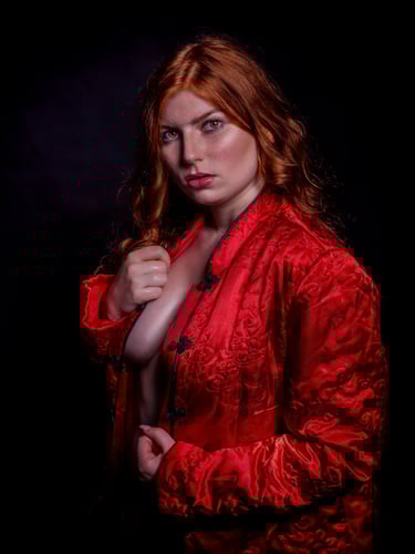 Fashion-Portrait einer Frau mit roten Haaren und roter Jacke im Studio