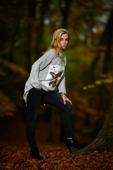 Porträt einer Frau im grauen Pullover mit Tattoos, aufgenommen im herbstlichen Wald von Lens & Look | Cinematische Portraitfo