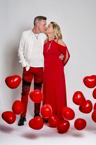 Liebespaar beim Valentinstags-Fotoshooting: Mann und Frau in roten Outfit