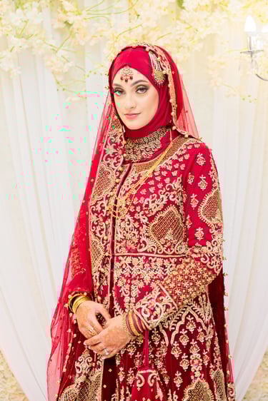 portrait of asian bride in traditional red and gold dress, light and airy photo, floral background blurred 