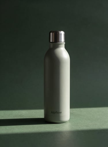 A sleek, minimalist product shot of the Alpflow bottle on an Off-White surface with soft shadows and Dark Forest Green accents.