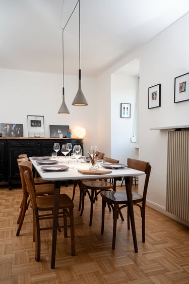 salle à manger conviviale avec des luminaires suspensions Aplomb de chez Foscarini
