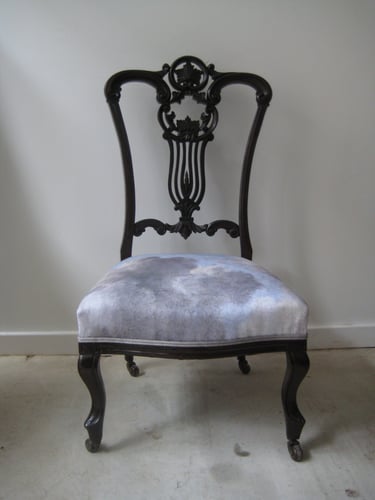 Antique dark wood nursing chair. With new upholstery and grey cotton fabric with a cloud design
