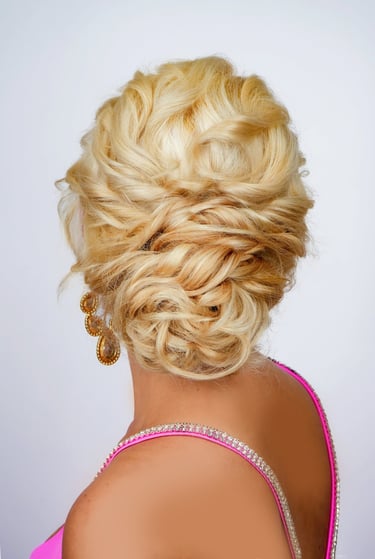 Bride with blonde hair in textured updo featuring intricate braids and volume, elegant formal hairstyle perfect for weddings.