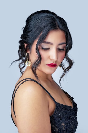 Bride with elegant bridal updo, soft wedding makeup, long lashes, neutral eyeshadow, bold red lipstick, and gold earrings.