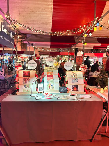 Feestelijke kraam op Kerstmarkt met rekken met Kadoentjes en feestelijke lampjes