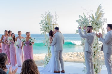 Un momento capturado de una pareja recién casada compartiendo un beso en una playa en Los Cabos, en Garza Blanca. Capturado p