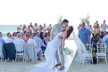Un momento capturado de una pareja recién casada compartiendo un beso en una playa en Los Cabos, en Garza Blanca. Capturado p