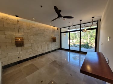 Imagen de espacio al interior de una casa remodelada con muros de piedra natural, pisos de mármol y ventanas de piso a techo