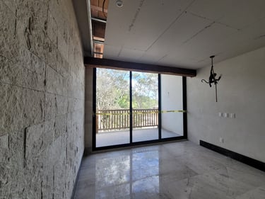 Espacio interior de casa en etapa de remodelación con muros de piedra natural y pisos de mármol