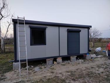 Sivi kontejner sa prozorom i vratima u antracit boji i roletnama Begec