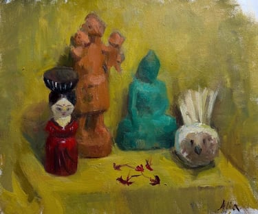 Still life with dolls and small sculptures on a yellow cloth 