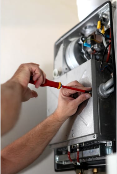 Technician using a screwdriver for gas boiler repair and annual boiler service