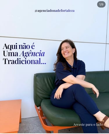 A smiling woman sitting on a green couch in a modern marketing agency setting.