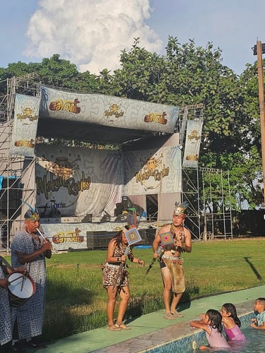 Indigenous performers dance and play music by a pool Centro Recreacional Mokanranko