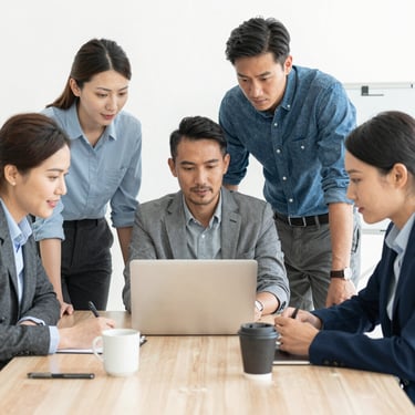 A sleek, modern laptop on a minimalist white desk showing a clean software code interface with syntax highlighting in teal #4CAF9D and dark blue #0F1D33. The background is a soft-focus office with professional lighting, projecting a high-end tech environment.