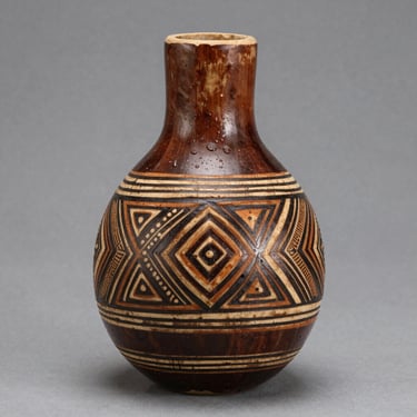 A vibrant installation piece featuring layered textiles and sculptural forms bathed in warm gallery lighting.