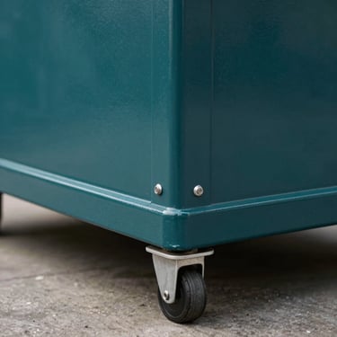 An auto-lock bottom carton designed for heavy-duty retail, showing its sturdy base and professional dark teal color palette.
