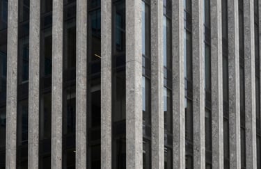 A minimalist architectural detail of a modern building facade featuring strong vertical lines, granite and glass, North American business center.