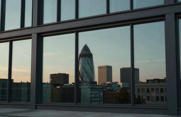 An aesthetic shot of a modern building facade with large glass windows reflecting the Berlin skyline during twilight. Dominant colors are dark charcoal and pale celadon.
