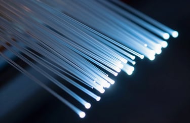 Abstract macro photography of fiber optic cables in a North American / US tech hub, glowing with soft white and steel blue light.