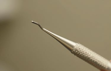 Macro shot of a modern dental tool reflecting soft gold light, representing clinical precision and modern technology in an olive-toned environment.
