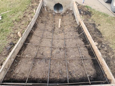 Concrete formwork with rebar for culvert channel.