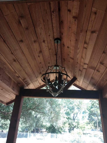 Wood-paneled gable ceiling with chandelier.