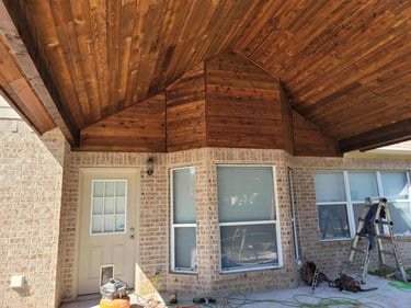 Covered patio area with stained wood vaulted ceiling.