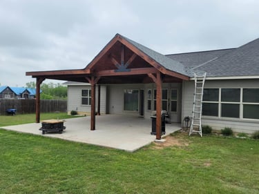 Covered backyard patio with wood gable roof.