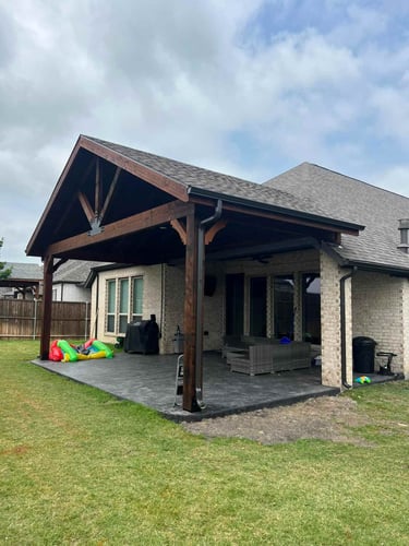Gable-style covered patio with dark wood beams.