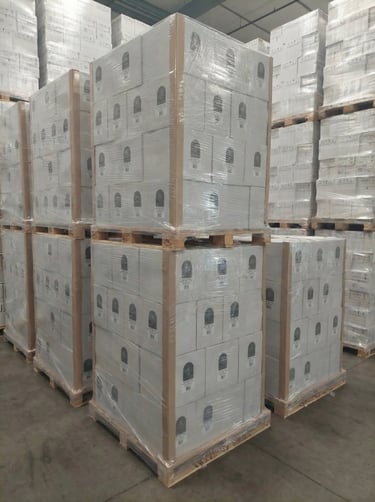 Pallets met krimpfolie verpakte dozen staan ​​opgestapeld in een magazijn voor logistiek en distribu