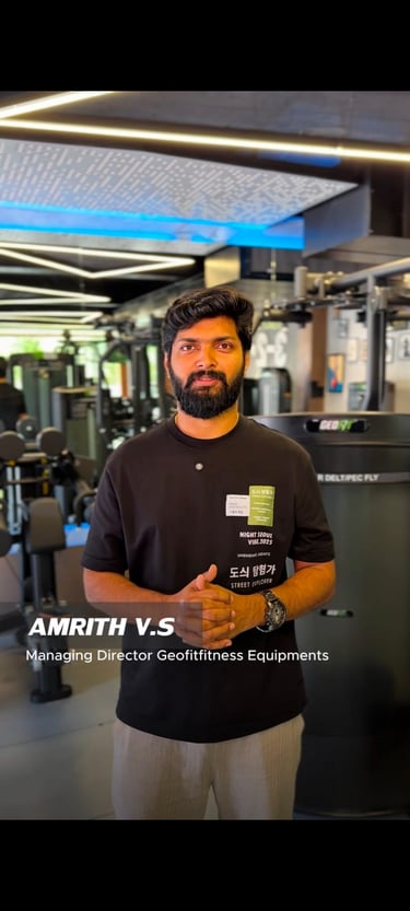 Amrith V.S, Managing Director of Geofitfitness Equipments, standing in a modern commercial gym.