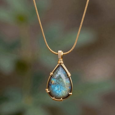 Teardrop labradorite gemstone pendant with a wire-wrapped design on a delicate gold chain, highlighting its iridescent blue