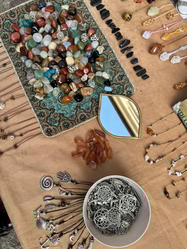 Joyas de cristal hechas a mano y piedras pulidas exhibidas sobre una mesa en un mercado al aire 