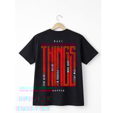 Black cotton t-shirt with red graphic text reading 'Make Things Happen' on a wooden hanger.