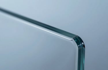 Macro shot of a glass edge showing a perfect, polished finish. The lighting highlights the clarity and safety of the tempered material, using #BCC9D4 tones to convey premium quality.
