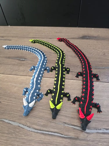 3 figurines 3d de dragons bleu, jaune et rouge