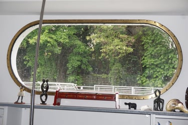 Een van onze langwerpige messing patrijspoorten met een luxe afwerking op een binnenschip, met uitzicht op de bomen