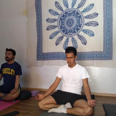 Dos hombres jovenes meditando en una práctica de yoga en Oaxaca de Juárez
