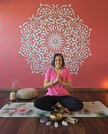 Mujer sonriente practicando yoga en Oaxaca sobre una esterilla con cuencos tibetanos y cuarzos