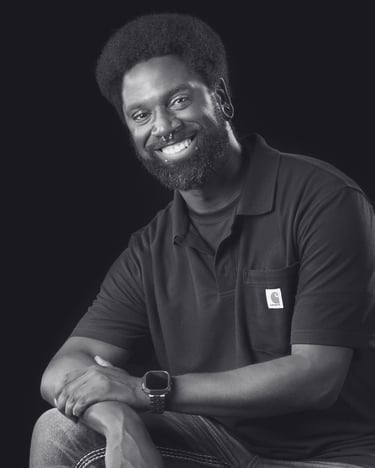 Smiling man with beard wearing a Carhartt polo shirt in a black and white professional portrait.