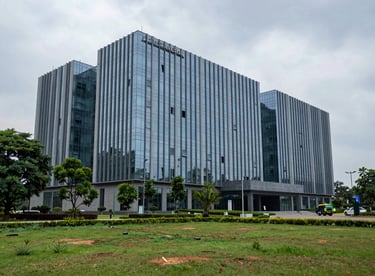 The modern glass facade of a prestigious medical university in Hyderabad surrounded by green landscaping.