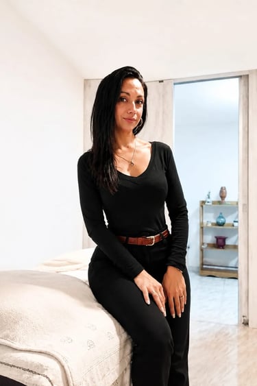 Avril vestida con un elegante conjunto negro sentada en su espacio de masajes en Almagro.