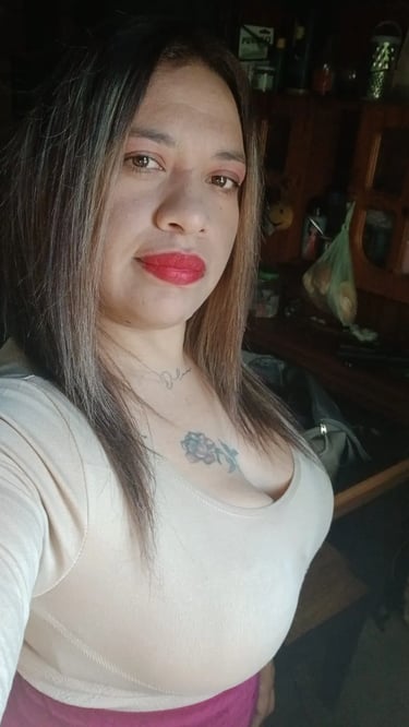 Vale masajista sensual en Caballito, posando de frente con blusa clara en su espacio de relax.